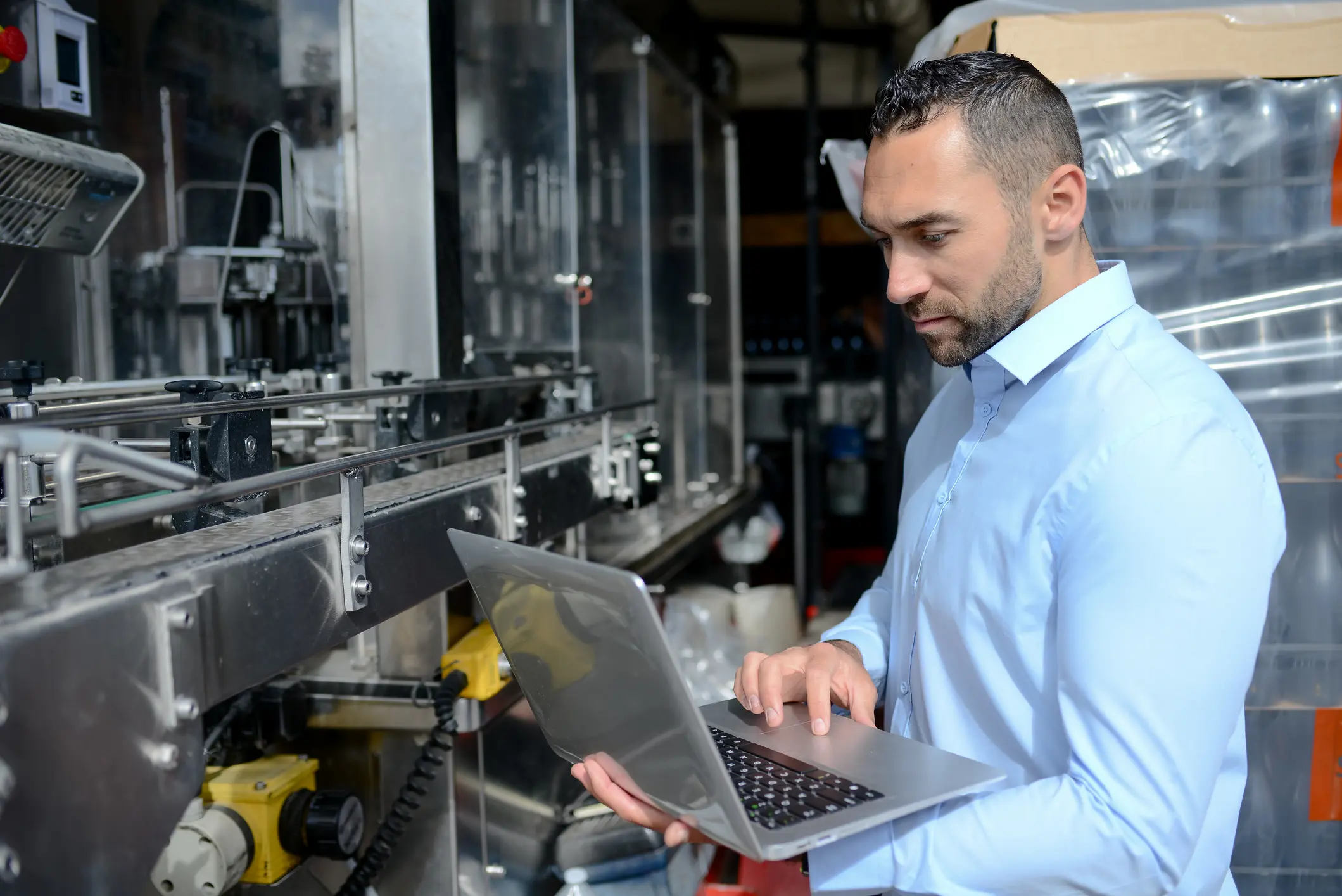 young man wine maker working filling wine bottle with automatic bottling machine