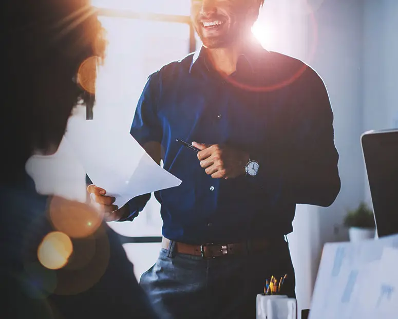 Young team of coworkers making great meeting discussion in modern coworking office.Hispanic businessman talking with two beautiful womans.Teamwork process.Horizontal,blurred background,sun effect